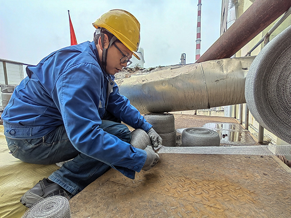 5月10日中午，在動力車間三期工藝除氧器平臺上，黨員突擊隊隊員劉瑞斌正在纏繞新填料.jpg