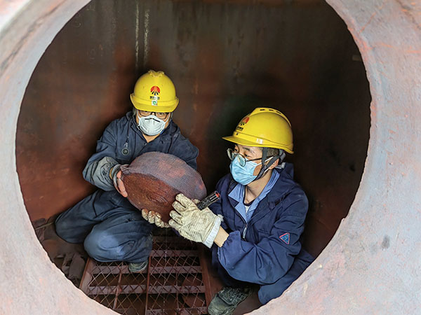 5月11日，動力車間三期工藝除氧器內部，黨員突擊隊隊員劉瑞斌和李震正在清理舊填料.jpg